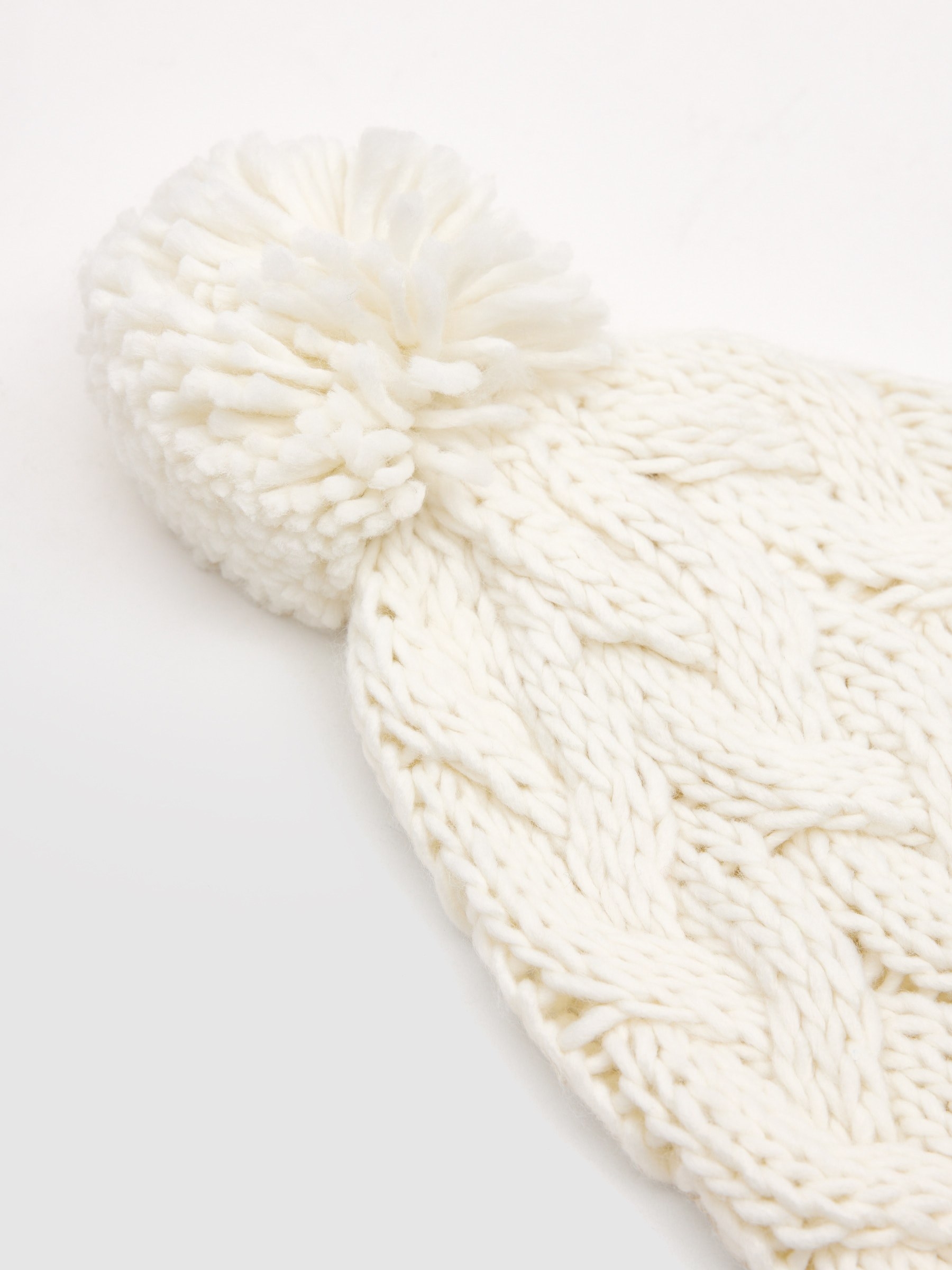 Gorro trenzado pompón blanco vista lateral frontal 45º
