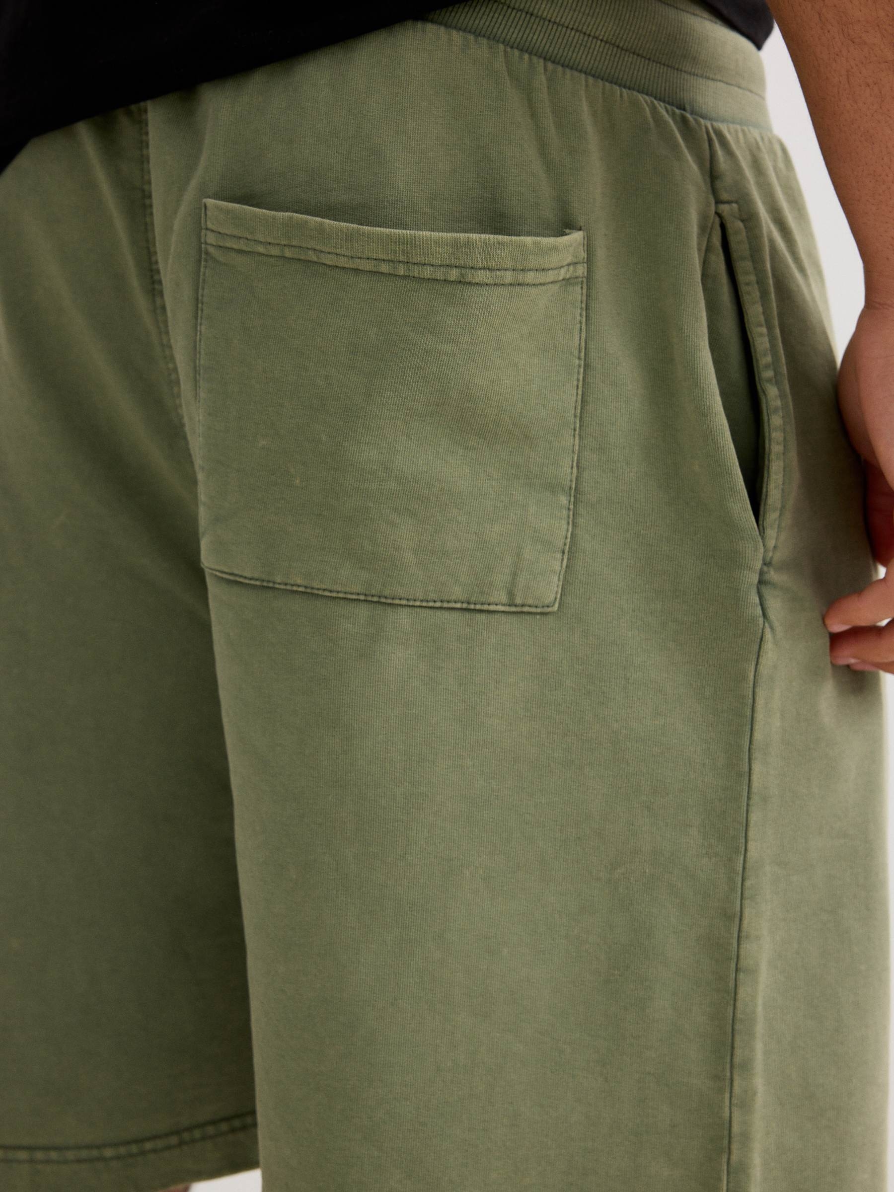 Bermuda esportiva felpuda com cordões verde vista meia frontal