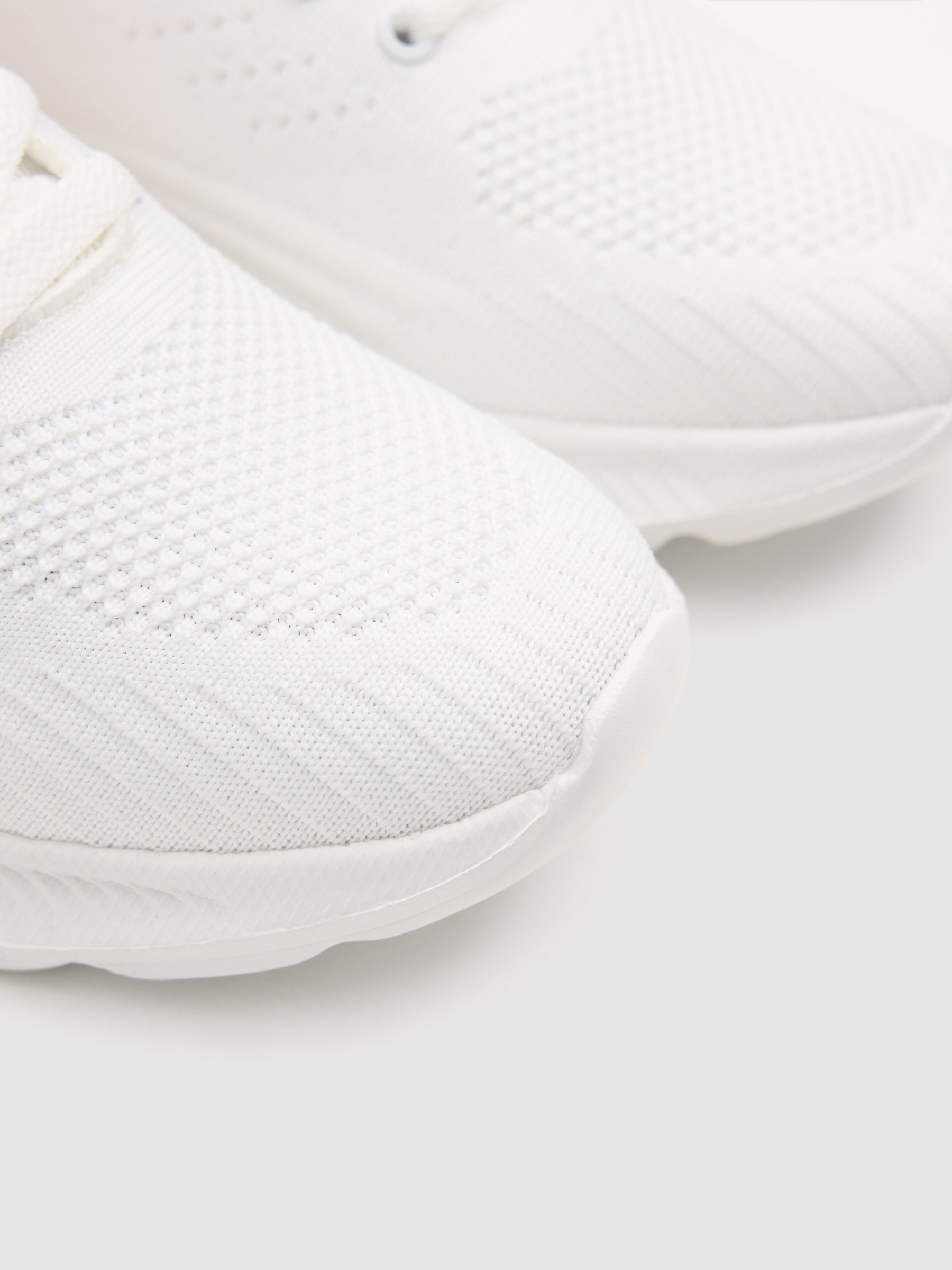 Esportiva de couro sintético com zíper branco vista frontal 45º