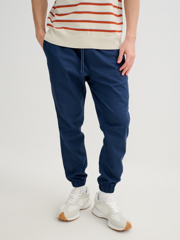 Calça jogger elástica azul petróleo vista meia frontal