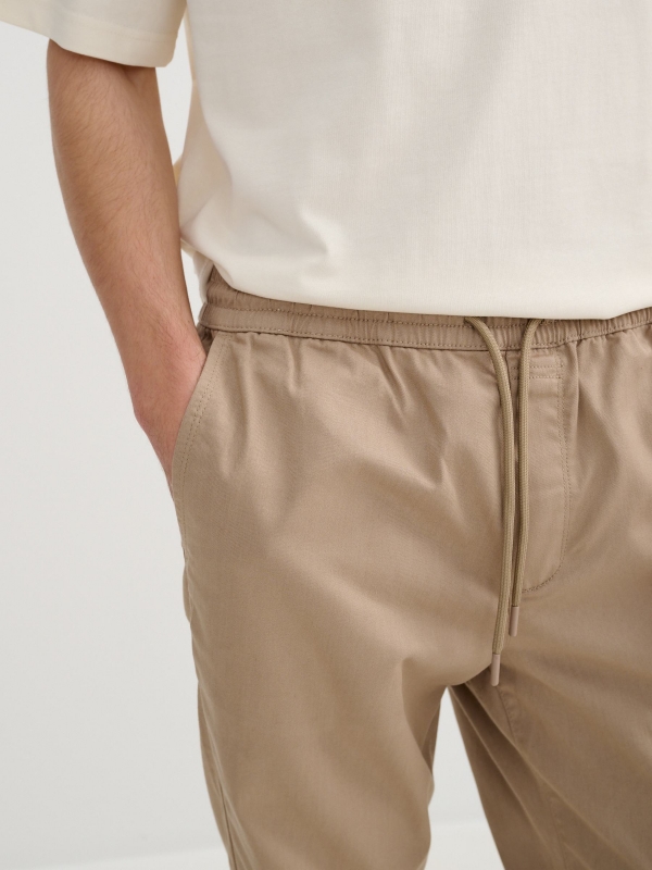 Calça jogger elástica bege vista detalhe