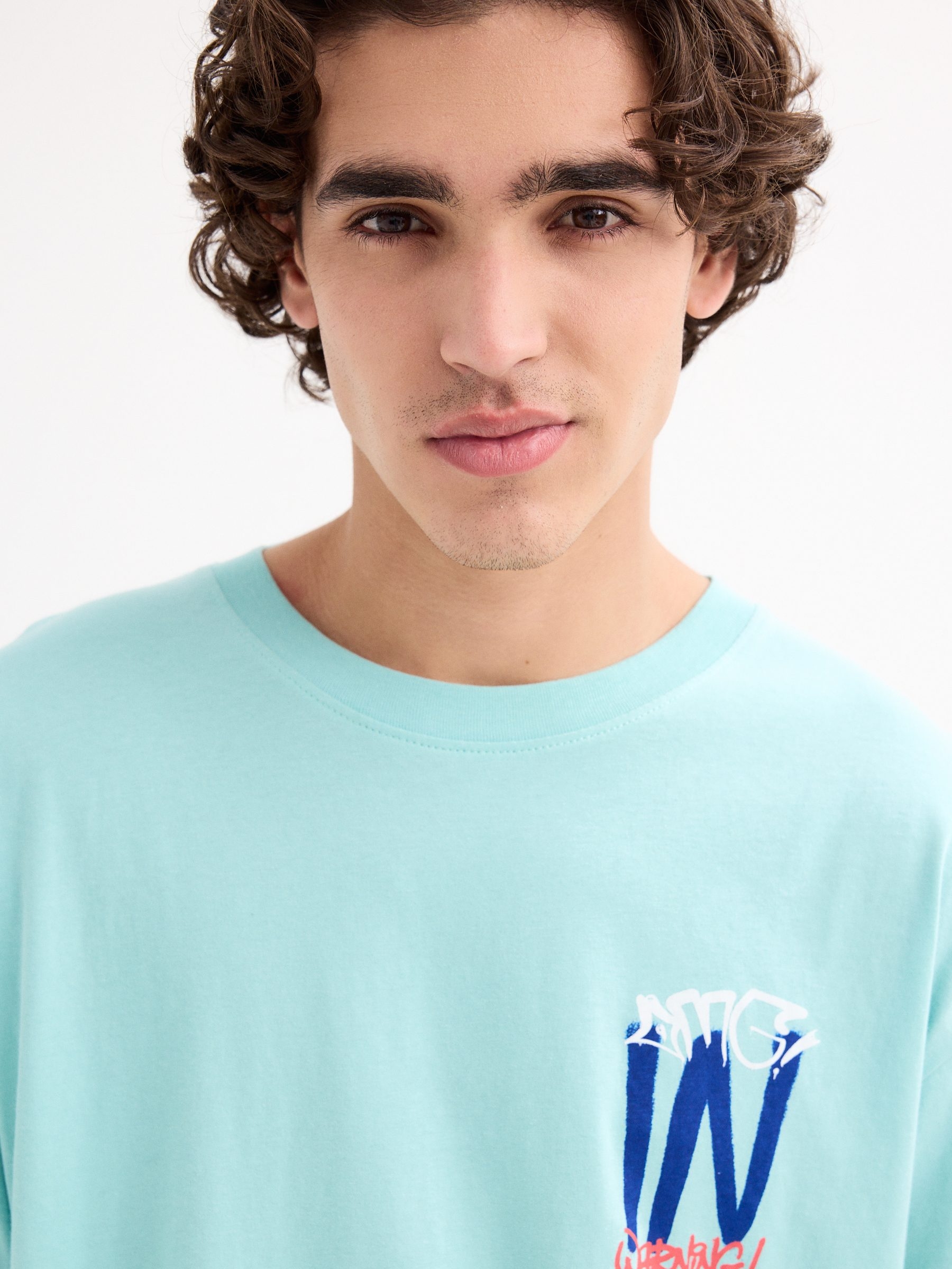 T-shirt com logótipo de graffiti azul claro vista meia frontal