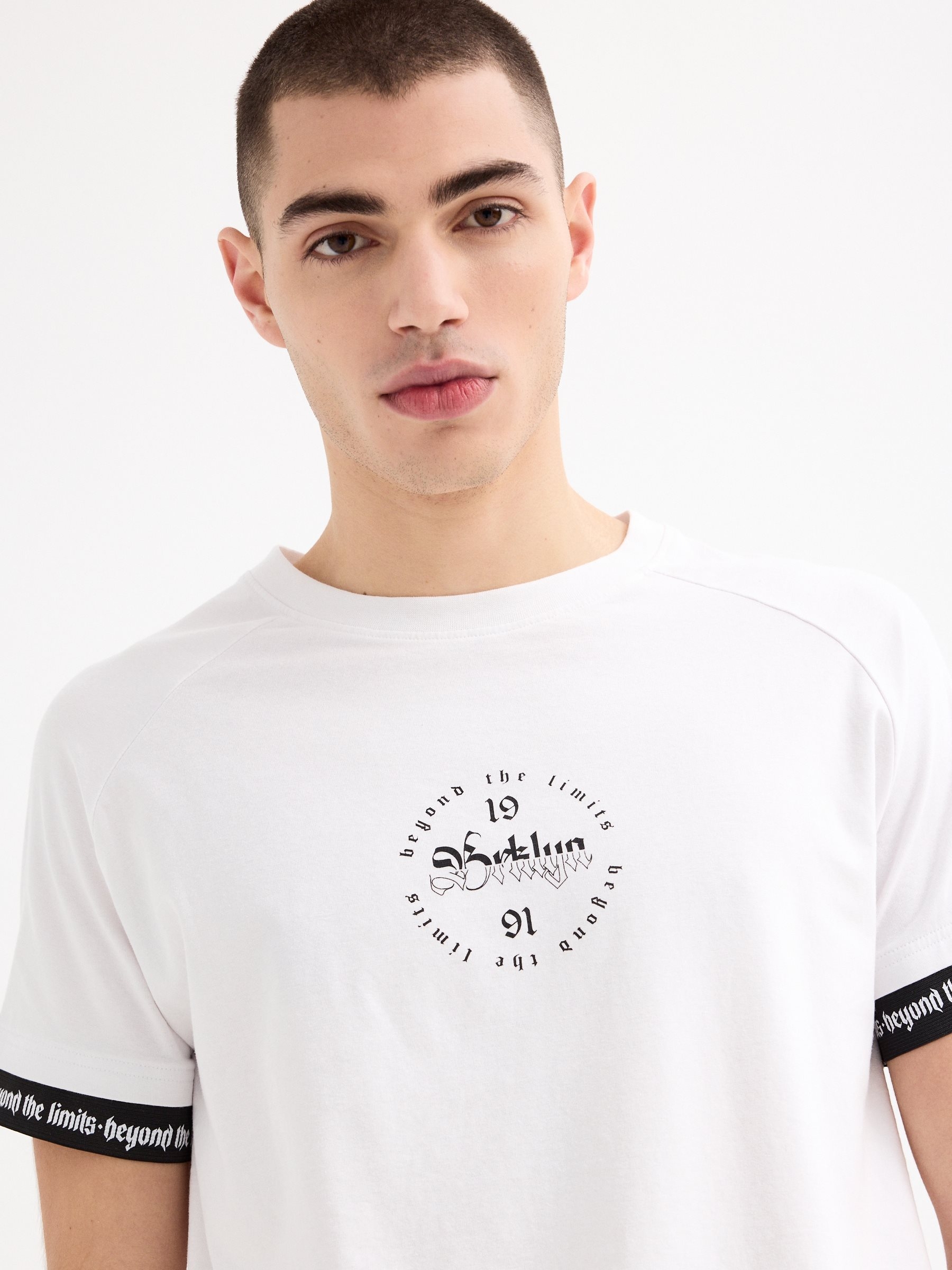 T-shirt raglan com pormenor de texto branco vista meia frontal