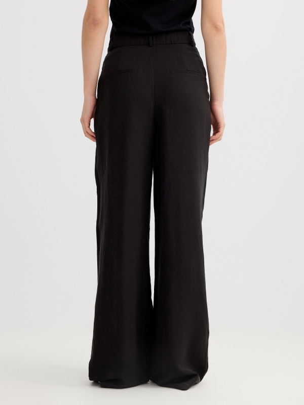 Pantalón pinzas wide leg asimétrico negro vista media trasera