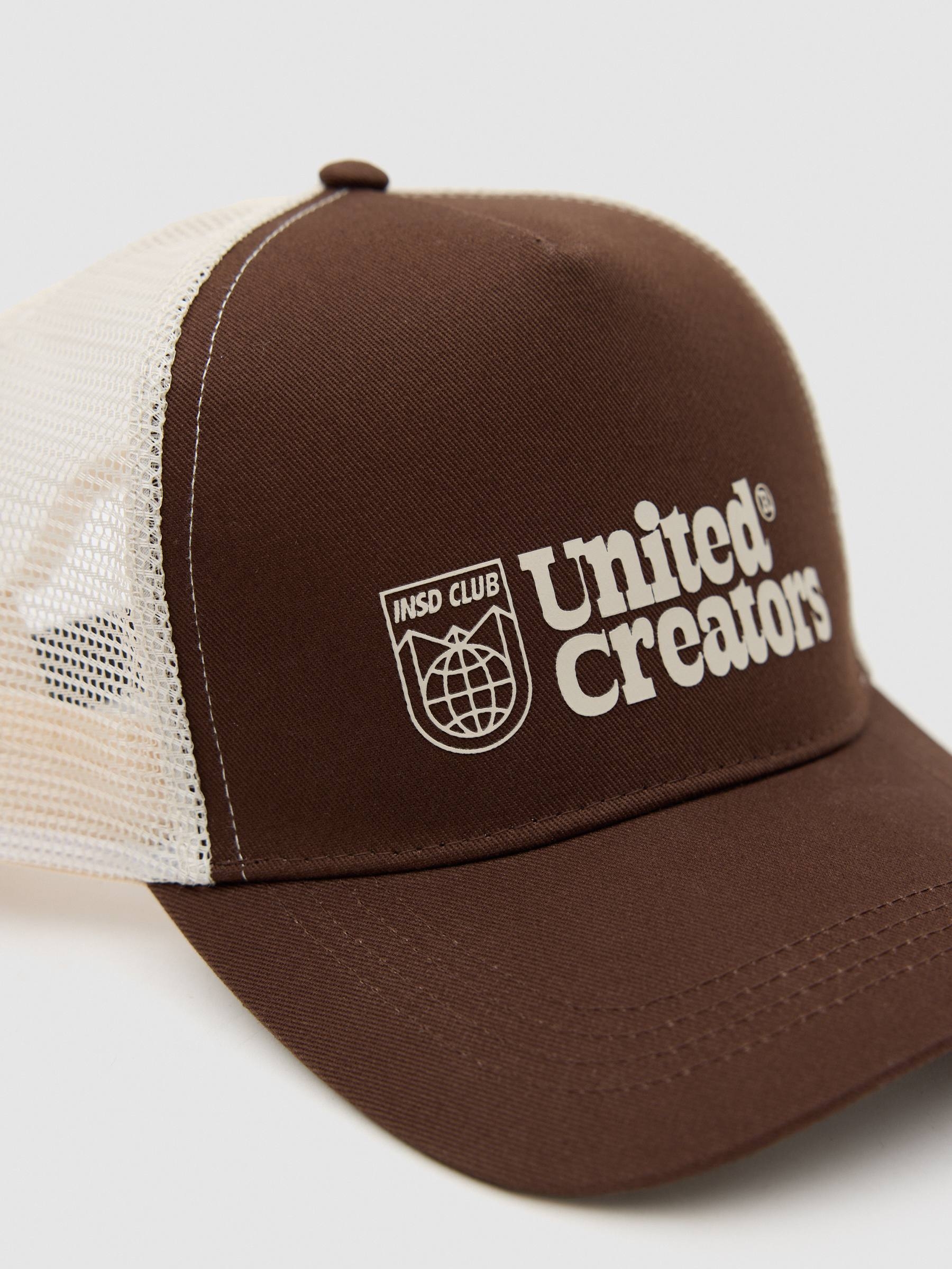 Gorra trucker united creators marrón vista lateral frontal 45º