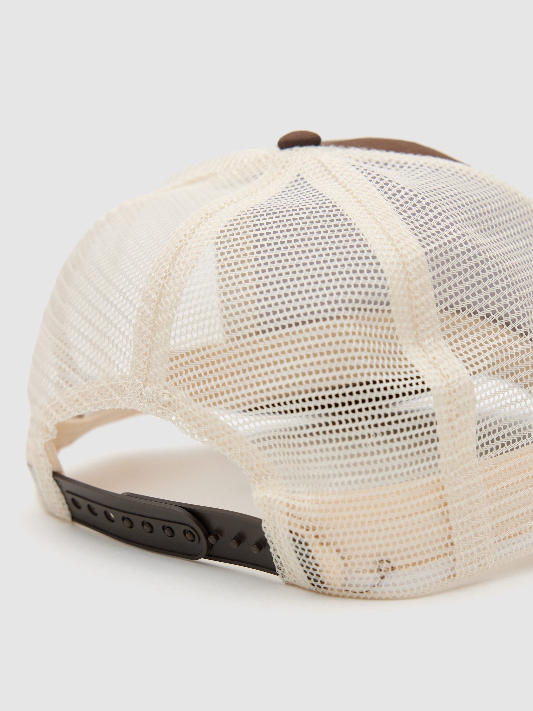 Gorra trucker united creators marrón vista lateral frontal 45º