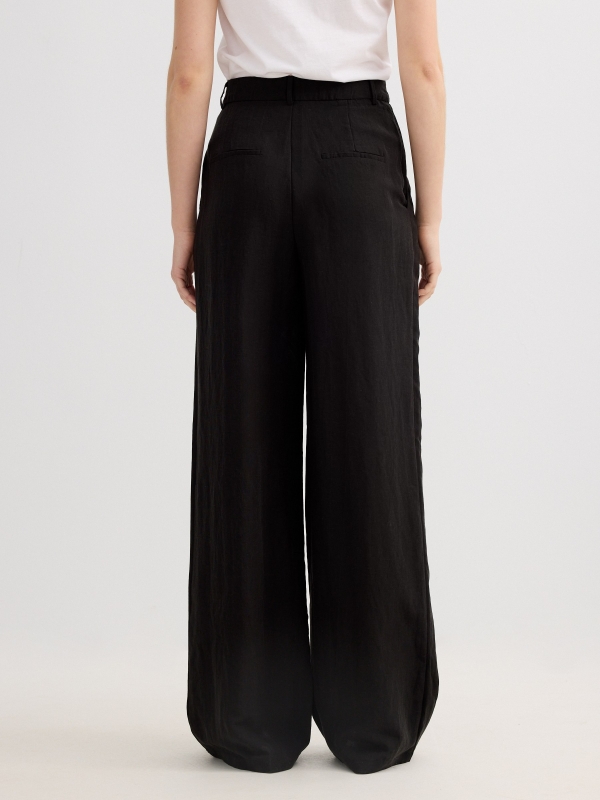 Pantalón pinzas wide leg asimétrico negro vista media trasera