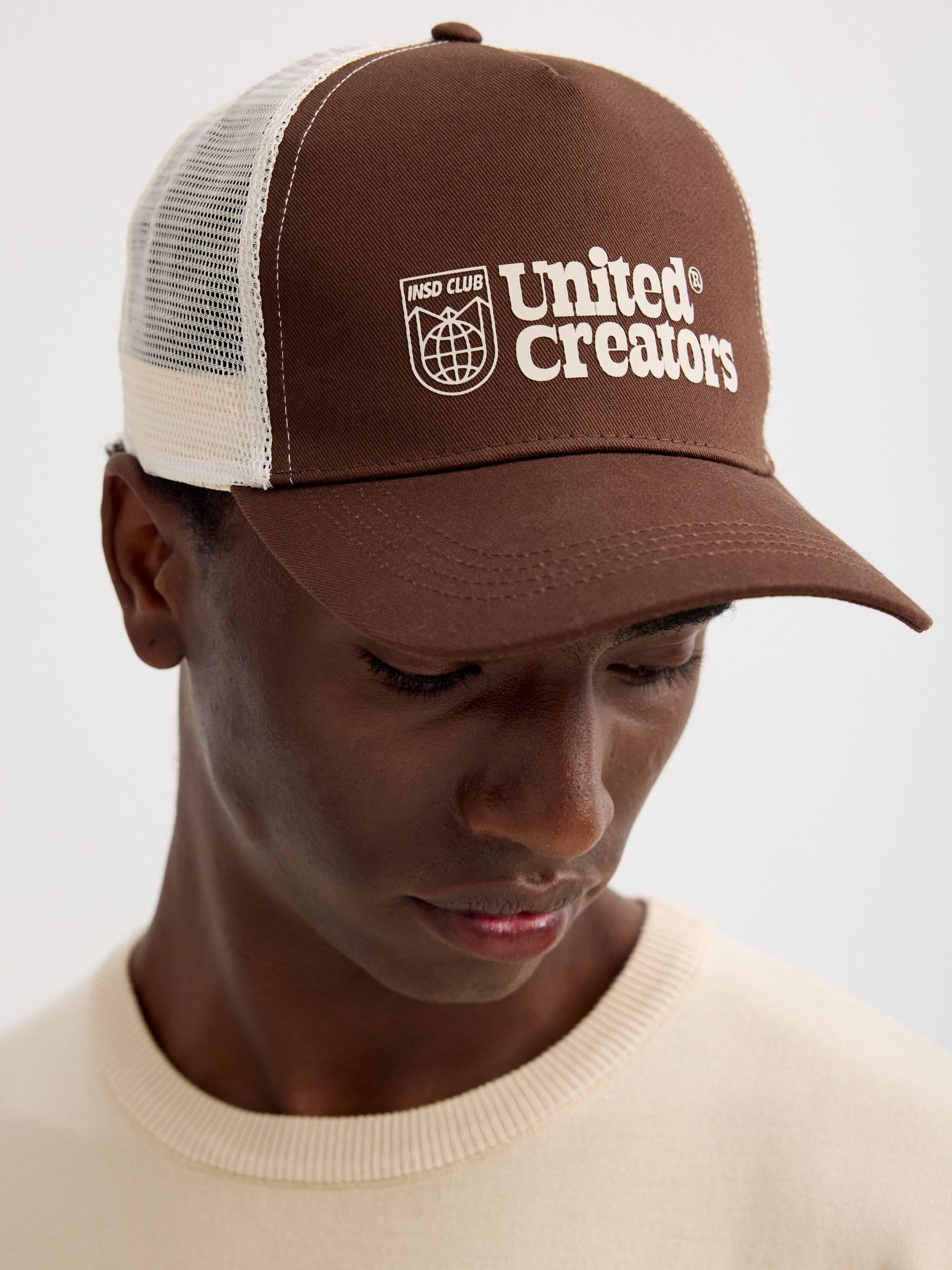 Boné trucker united creators marrom vista lateral frontal 45º