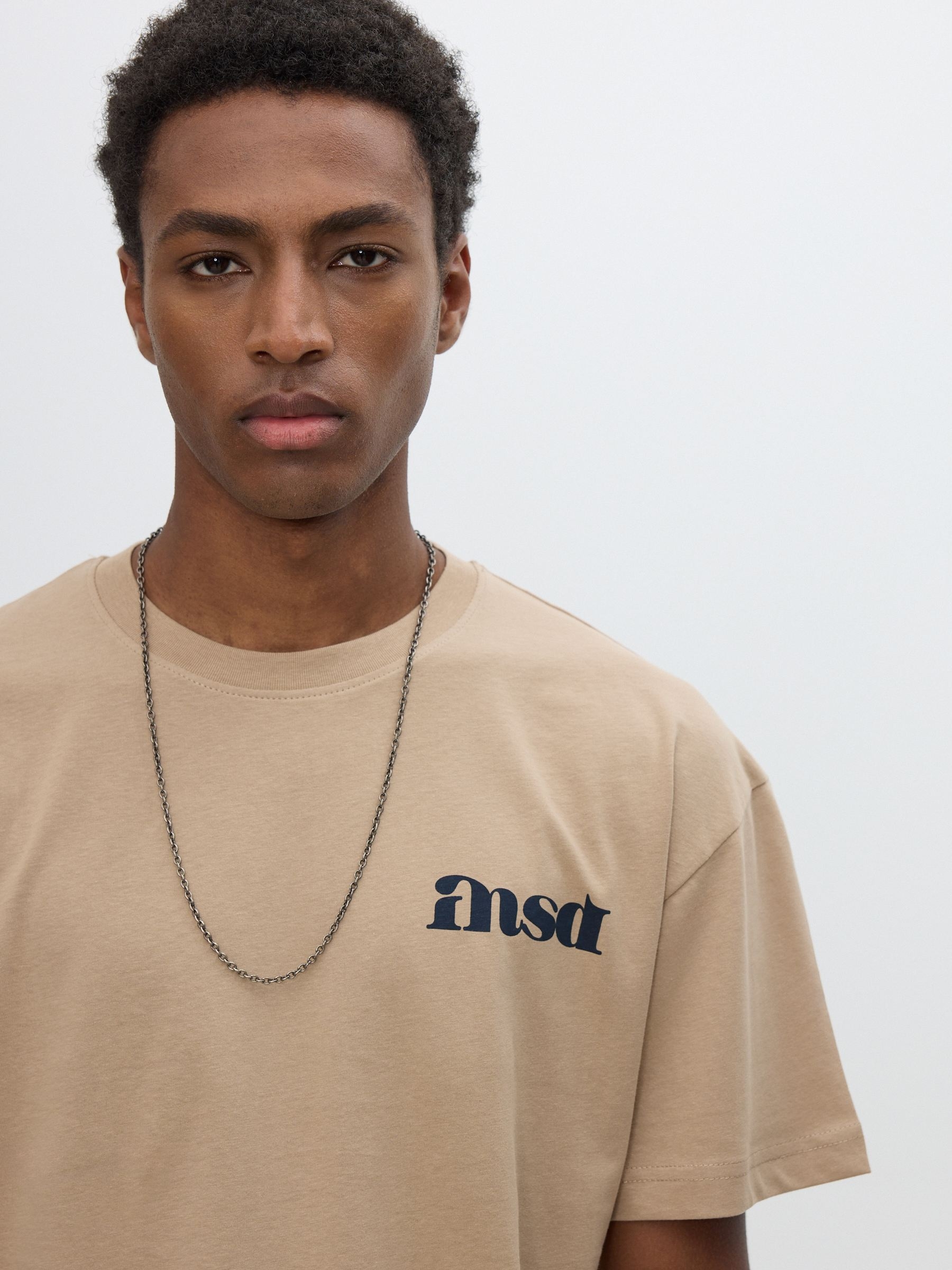 Camiseta estampada com texto bege vista meia frontal