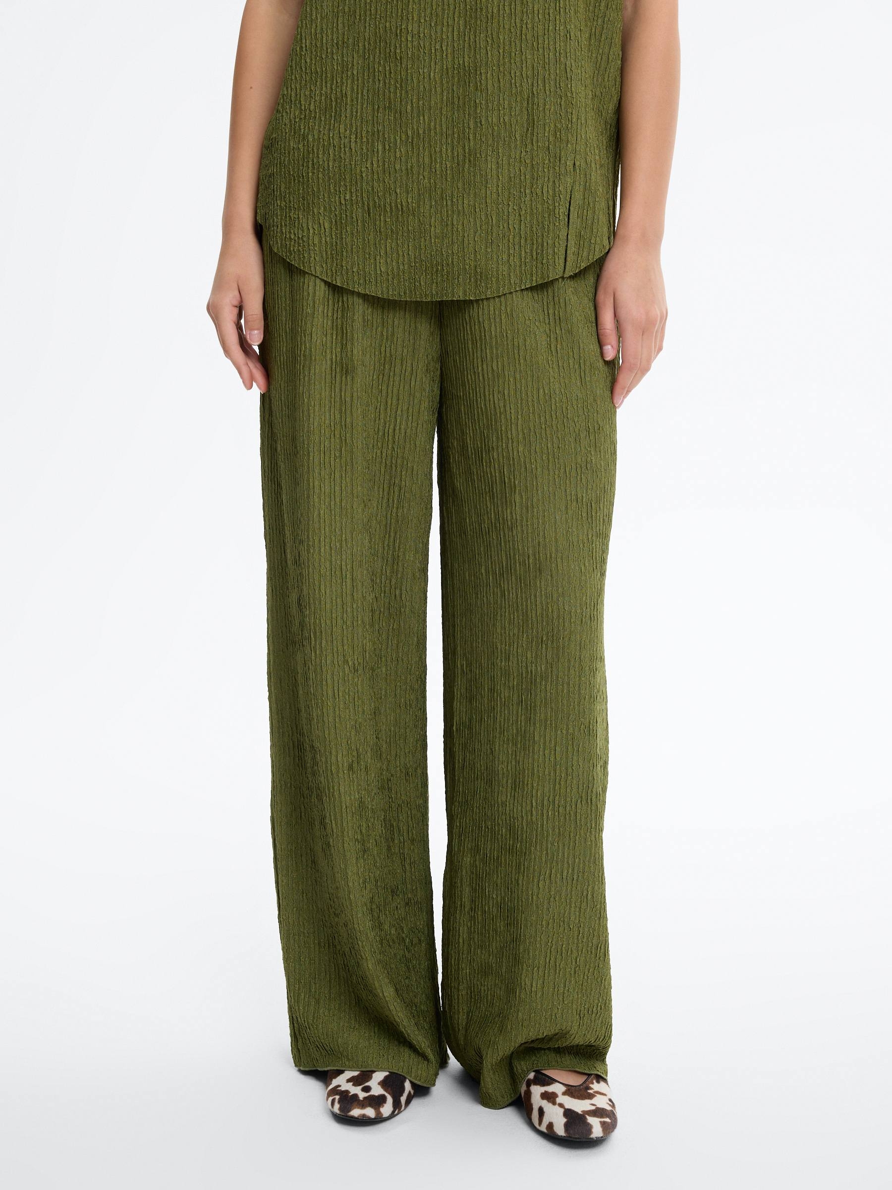 High-waisted textured flowy pants green front view