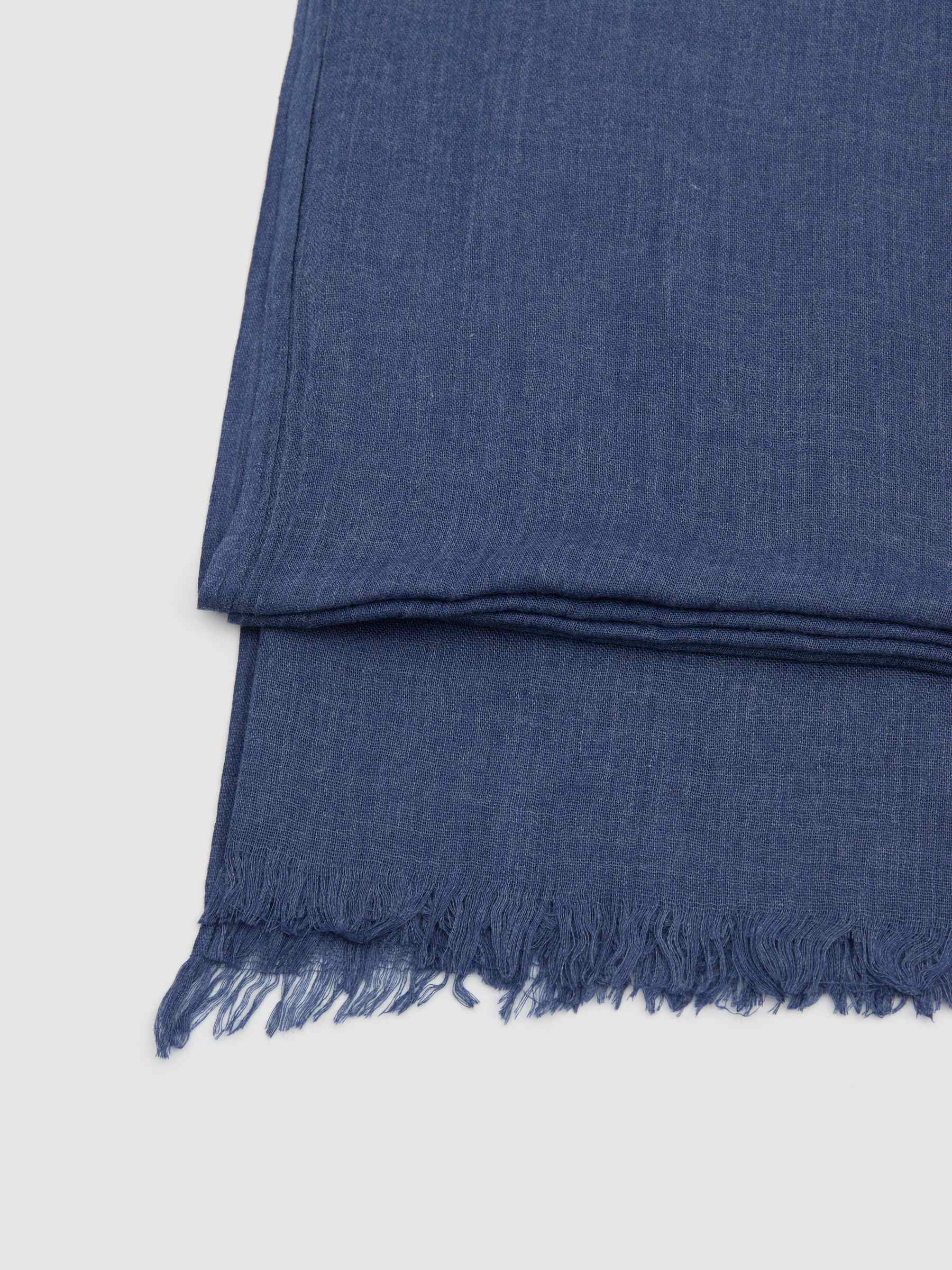 Lenço liso com franjas azul vista enrolado